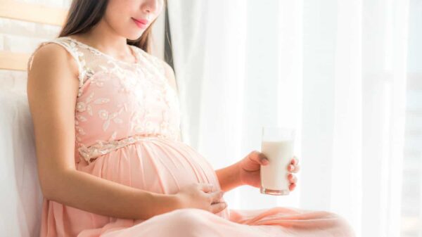 image of a young woman drinking orange juice with a straw